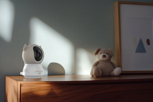 peekyboo non-wifi 2k baby camera on top of a dresser with a teddy bear in the background and sharp directional lighting